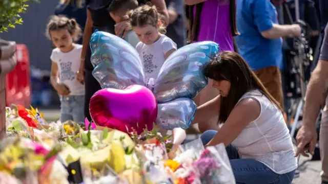 People lay flowers near the scene in Hart Street, Southport