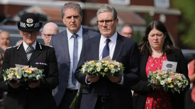 Prime Minister Keir Starmer carrying a floral tribute near the scene in Hart Street, Southport