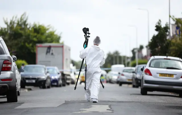 A police forensics officers walking down a street