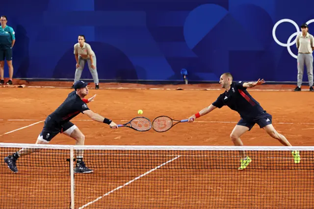 Andy Murray of Team Great Britain and Dan Evans of Team Great Britain stretch for the same ball