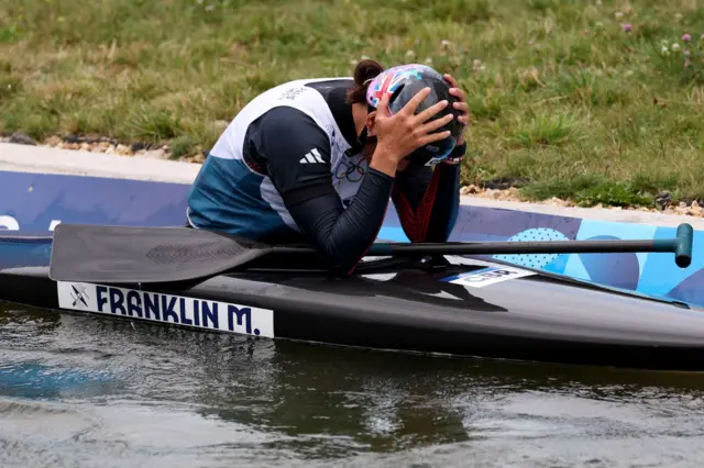 Franklin puts her hands to her helmet after a poor run