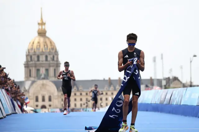 Alex Yee holds the finishing banner