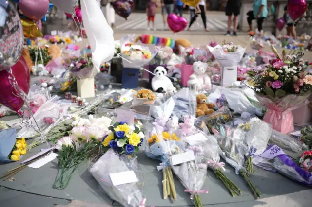 A collection of bouquets, teddy bears  and balloons