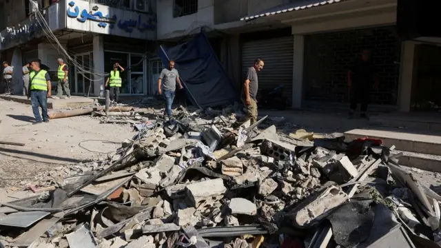 People walk on the rubble of a damaged site the day after an Israeli strike, in Beirut's southern suburbs, Lebanon July 31, 2024.