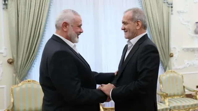 Iranian president Masoud Pezeshkian (on the right of the picture) shaking hands with Ismail Haniyeh. Both men are smiling