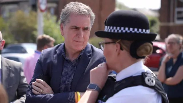 Rotheram crosses his arms as he listens to kennedy, in uniform