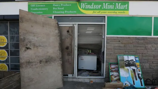 Scene outside the mini mart with signs and boxes piled up on the floor