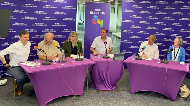 Andrew Pakes, Nick Sandford, Nicola Day, Chris Mann, Paul Bristow and Sue Morris all sitting behind desks with microphones in front of them during the debate.