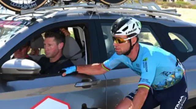 Mark Renshaw in the Astana Qazaqstan team car with Mark Cavendish on his bike holding on to the car door