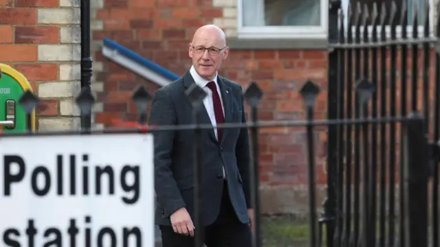 Scottish First Minister John Swinney walks outside a polling station in Burrelton