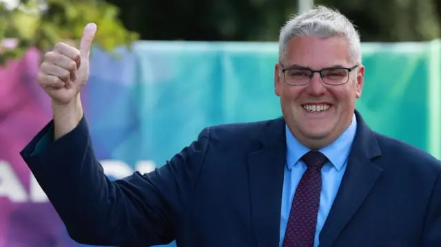 Gavin Robinson gestures after casting his vote