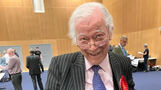 Former Workington MP Dale Campbell-Savours wearing a red rosette