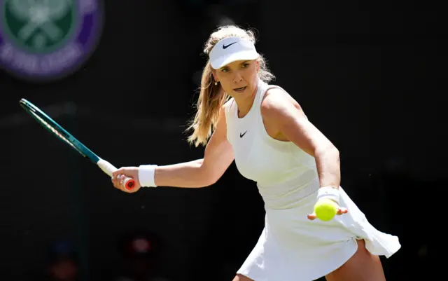 Katie Boulter hits a forehand shot wearing an all-white dress