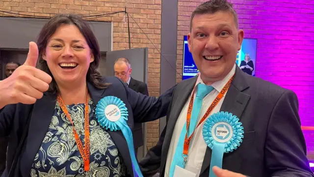 Georgina Hill (left) gives thumbs up and smiles at the camera with Mark Peart