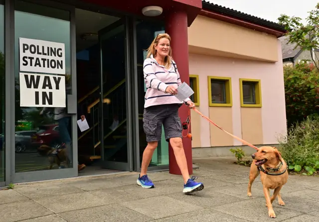 woman and dog at polling station