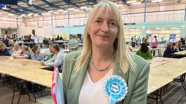 Women with Reform Party rosette in counting hall