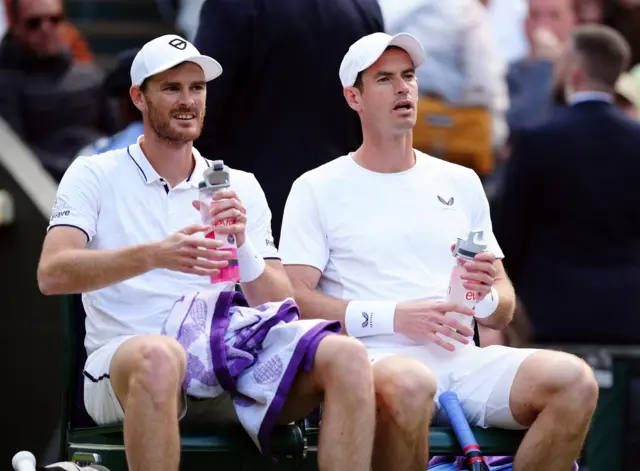 Jamie and Andy Murray sit down on the bench at a change of ends