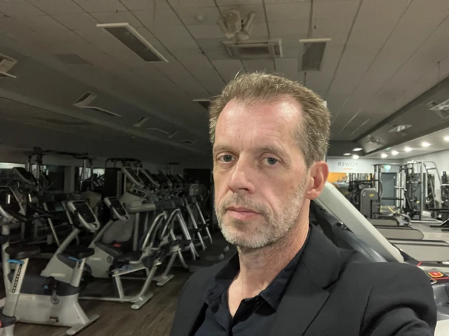 Patrick O'Hagan in a gym with gym equipment behind him