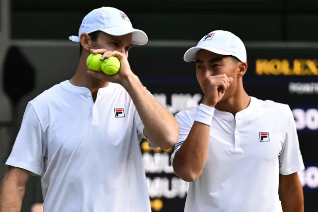 Australia's Rinky Hijikata (R) and Australia's John Peers discuss tactics on the court