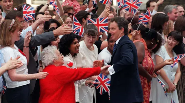 Tony Blair meets well-wishers holding Union Jacks outside Downing Street, following Labour's landslide victory in 1997