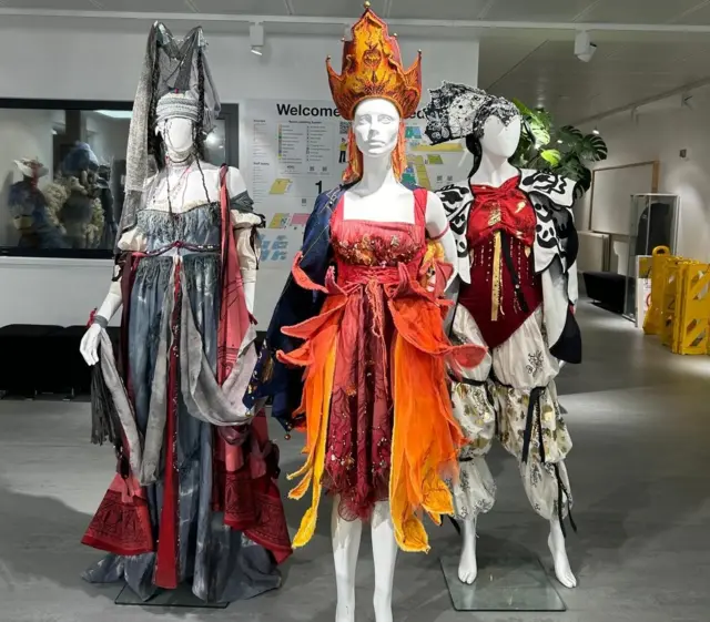 Three mannequins draped in ornate costumes