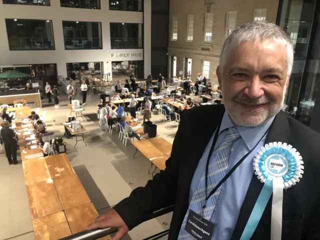 Image of Malcolm Cupis with counting hall in background