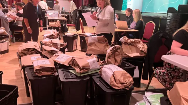 Ballot boxes being allocated to counting tables