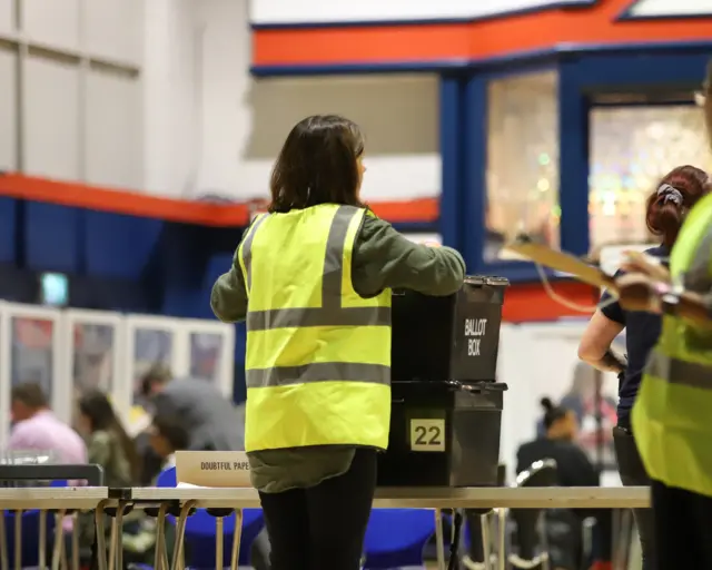 A person with ballot boxes