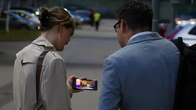 Two people watching a phone