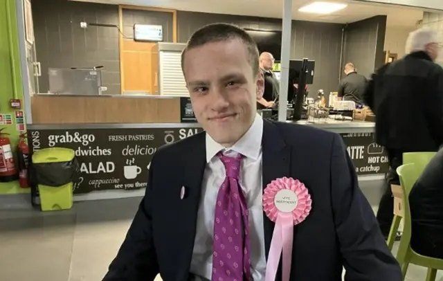 Samuel Cladingbowl wearing a pink rosette