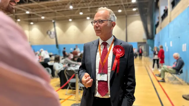 Dr Simon Opher is in Stroud count wearing red tie