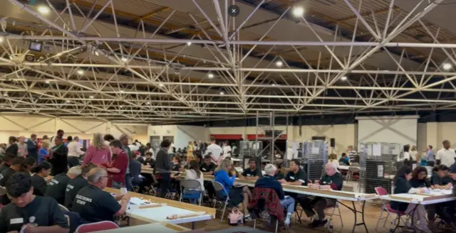 Picture of the scene at the count in Harrow showing tables of vote counters