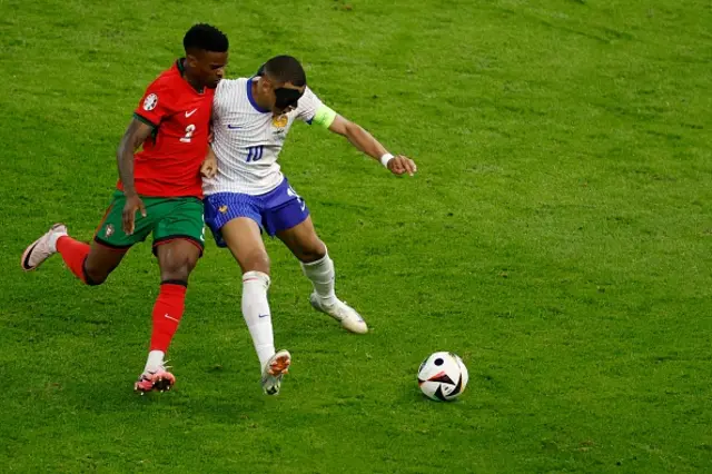 Nelson Semedo fights for the ball with France's forward #10 Kylian Mbappe