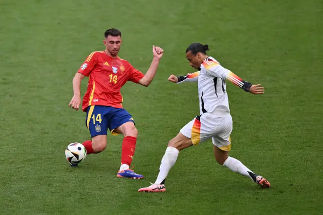 Aymeric Laporte of Spain passes the ball whilst under pressure from Leroy Sane