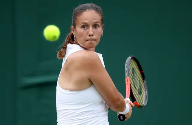 Daria Kasatkina hits a backhand shot wearing an all-white dress