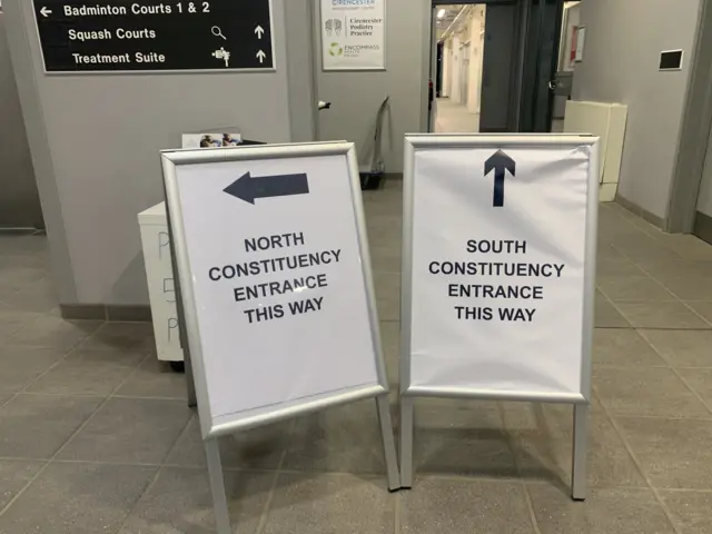 Two signs with arrows reading "north constituency entrance this way" and "south constituency entrance this way"