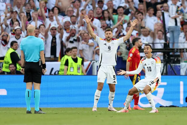 Jamal Musiala of Germany appeals to Referee Anthony Taylor for handball