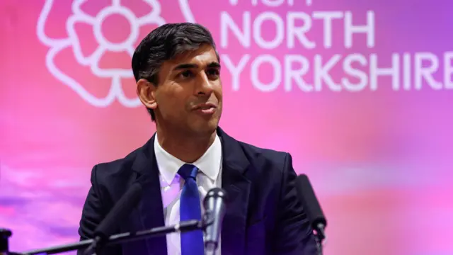 British Prime Minister Rishi Sunak speaks at a podium