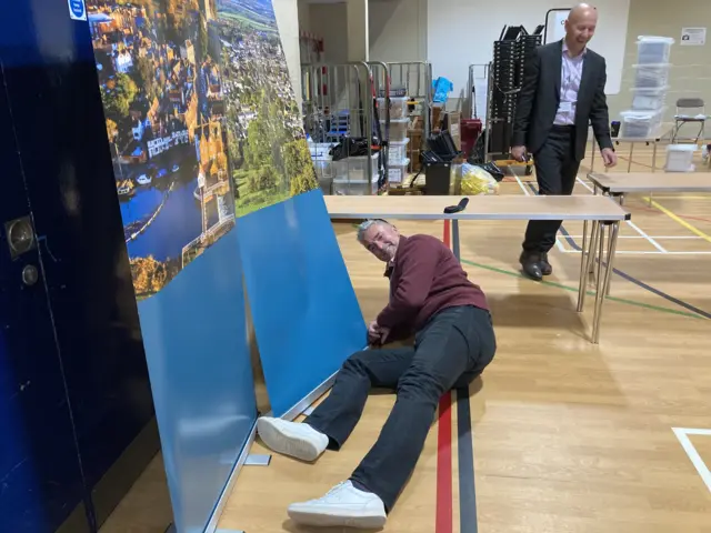 Gethin from Tewkesbury Borough Council repairing a backing screen in a leisure centre