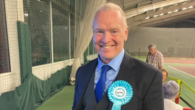 Reform UK candidate, Chris Farmer, in a blue suit at the Gloucester count in the 2024 general election