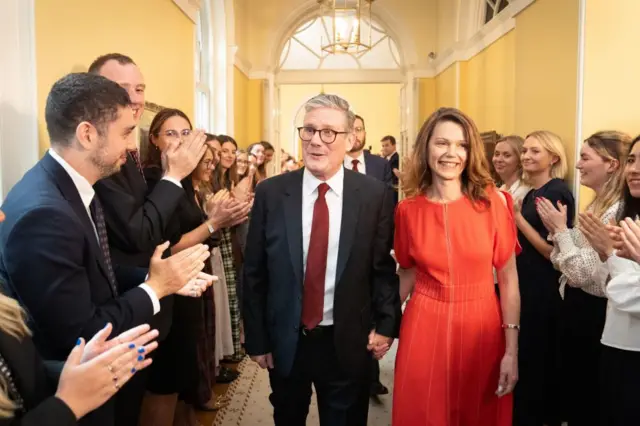 Newly elected Prime Minister Sir Keir Starmer with his wife Victoria Starmer are clapped in by staff as they enter his official London residence at No 10 Downing Street for the first time