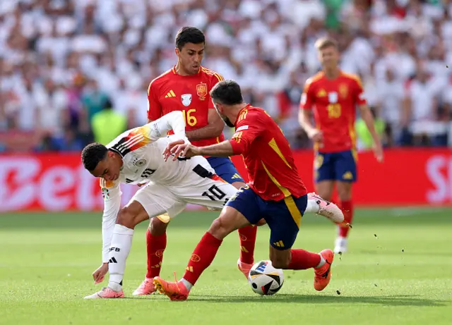 Jamal Musiala of Germany runs with the ball whilst under pressure from Rodri and Daniel Carvajal