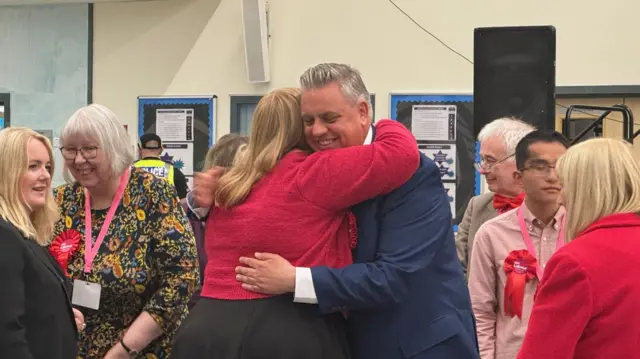 Candidate Blair McDougall hugs woman