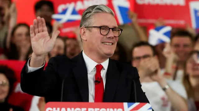 Sir Keir Starmer grins and waves to supporters