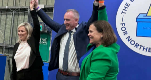 Cathal Mallaghan punches the air along with Michelle O'Neill and Mary Lou McDonald