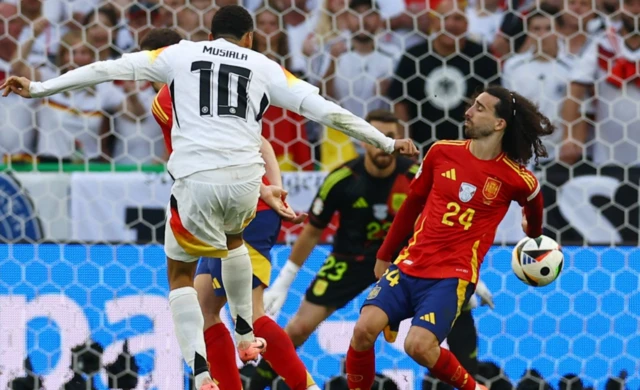 Germany's Jamal Musiala shoots at goal and hits the arm of Spain's Marc Cucurella