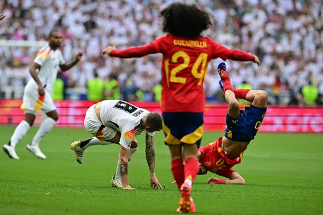 Pedri and Germany's midfielder Toni Kroos react after colliding