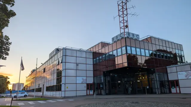 The sun rises on a large glass BBC building