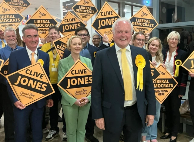 Clive Jones - wearing a yellow tie - and supporters at the count in Wokingham