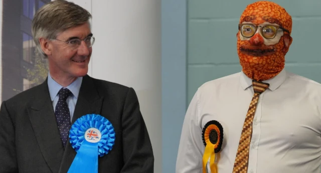 Jacob Rees-Mogg smiles while looking at Phin “Barmy Brunch” Adams, who has a balaclava covered in a baked bean design